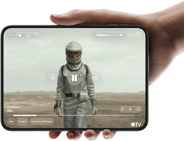 iPhone Duo, tenuto con una mano in orizzontale, completamente aperto; il display interno mostra la serie “Silo” di Apple TV